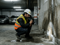 tecnico inspeccionando filtraciones de agua en garaje subterraneo antes de pavimentar